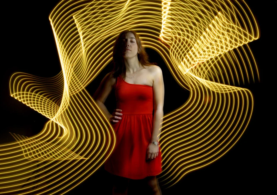 Light Painting portrait with a red dress and golden light waves